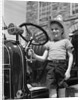 1930s Smiling Boy Standing Next To Fire Engine Wearing Firemans Hat by Anonymous