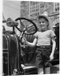 1930s Smiling Boy Standing Next To Fire Engine Wearing Firemans Hat by Anonymous