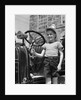 1930s Smiling Boy Standing Next To Fire Engine Wearing Firemans Hat by Anonymous