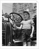 1930s Smiling Boy Standing Next To Fire Engine Wearing Firemans Hat by Anonymous