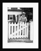 1940s Child Boy Standing Swinging On White Picket Fence Gate Smiling Looking At Camera by Anonymous