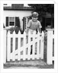 1940s Child Boy Standing Swinging On White Picket Fence Gate Smiling Looking At Camera by Anonymous