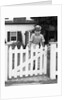 1940s Child Boy Standing Swinging On White Picket Fence Gate Smiling Looking At Camera by Anonymous
