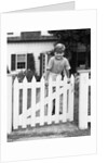 1940s Child Boy Standing Swinging On White Picket Fence Gate Smiling Looking At Camera by Anonymous
