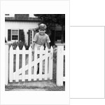 1940s Child Boy Standing Swinging On White Picket Fence Gate Smiling Looking At Camera by Anonymous