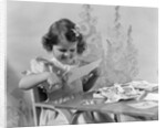 1940s Smiling Little Girl Cutting Paper With Scissors by Anonymous