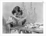 1940s Smiling Little Girl Cutting Paper With Scissors by Anonymous