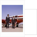 1960s Two Businessmen In Suits And Hats Carrying Briefcases Walking From A Small Twin Prop Business Airplane Talking by Anonymous