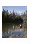 1970s Man Fisherman Red Shirt In Rocky Mountains Stream Lake Fly Rod Catch Splashing On Line Net by Anonymous