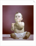 1940s 1950s Baby Diaper Sitting Looking Up Fingers In Mouth by Anonymous