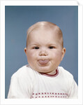 1960s Portrait Of Cute Blond Chubby Baby Looking At Camera Sticking Out Tongue by Anonymous