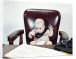 1960s Chubby Baby Sitting In Leather Office Chair Behind Desk Holding Talking On Telephone by Anonymous