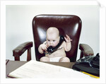 1960s Chubby Baby Sitting In Leather Office Chair Behind Desk Holding Talking On Telephone by Anonymous