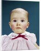 1960s Portrait Baby Girl Silly Facial Expression Red Bow At Collar Looking At Camera by Anonymous