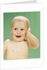 1960s Smiling Happy Baby Looking Off To The Side With Hand Touching Face by Anonymous