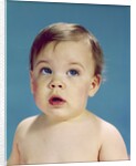 1960s Baby With Uncertain Facial Expression Deep Blue Eyes Looking Guilty Up And To The Side by Anonymous