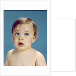 1960s Baby With Uncertain Facial Expression Deep Blue Eyes Looking Guilty Up And To The Side by Anonymous