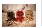 Black, red, and white pepper corns in rustic mason jars by Anonymous