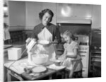 1950s mother and daughter baking a cake by Anonymous