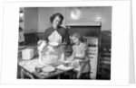 1950s mother and daughter baking a cake by Anonymous