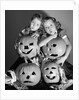 1950s boy and girl with four jack-o-lanterns by Anonymous