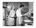 1950s smiling couple washing the dishes together by Anonymous