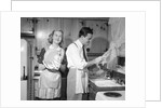1950s smiling couple washing the dishes together by Anonymous