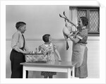 1940s housewife in kitchen showing plucked turkey to children by Anonymous