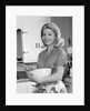 1960s 1970s smiling blond housewife in kitchen holding mixing bowl by Anonymous