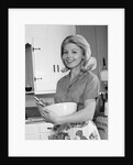 1960s 1970s smiling blond housewife in kitchen holding mixing bowl by Anonymous