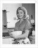 1960s 1970s smiling blond housewife in kitchen holding mixing bowl by Anonymous