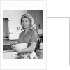 1960s 1970s smiling blond housewife in kitchen holding mixing bowl by Anonymous