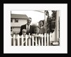 1950s family of four behind picket fence by Anonymous