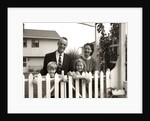 1950s family of four behind picket fence by Anonymous