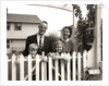 1950s family of four behind picket fence by Anonymous