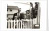 1950s family of four behind picket fence by Anonymous