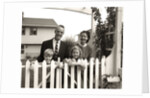 1950s family of four behind picket fence by Anonymous
