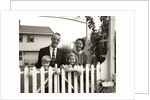 1950s family of four behind picket fence by Anonymous