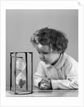 1940s young girl leaning on table staring at hourglass by Anonymous