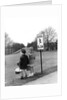 1930s 1940s boy and girl waiting to cross the road by Anonymous