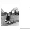 1930s 1940s boy and girl waiting to cross the road by Anonymous