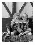 1960s boy and girl sharing a slice of watermelon by Anonymous
