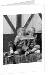 1960s boy and girl sharing a slice of watermelon by Anonymous