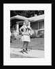 1950s girl on suburban sidewalk playing with a hula hoop by Anonymous