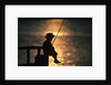 Silhouette of child fishing off a dock at sunset by Anonymous