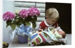 1970s boy holding a newborn baby by Anonymous