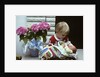 1970s boy holding a newborn baby by Anonymous