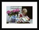 1970s boy holding a newborn baby by Anonymous