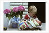 1970s boy holding a newborn baby by Anonymous
