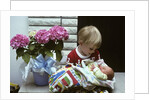 1970s boy holding a newborn baby by Anonymous